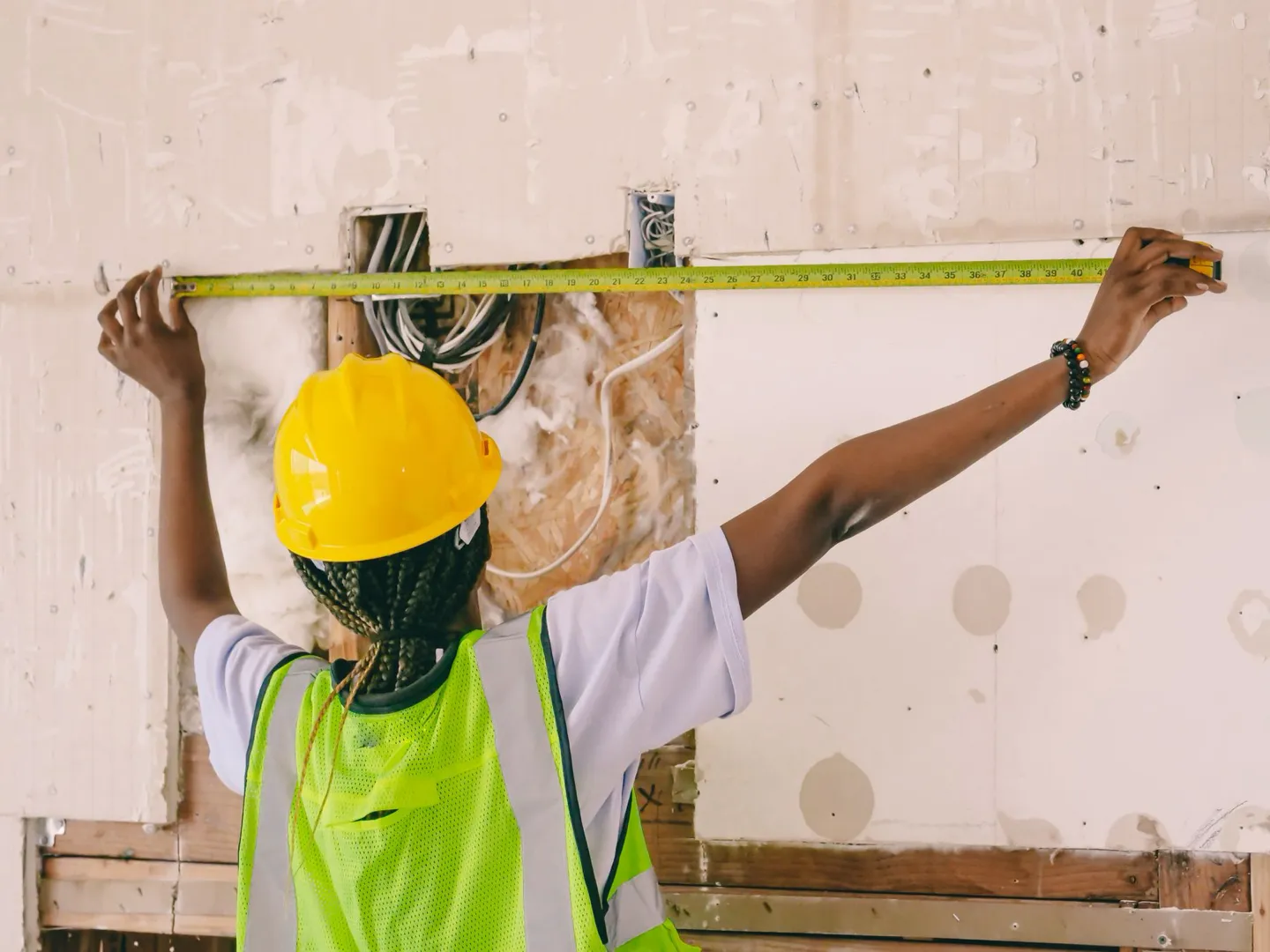 Designer measuring an interior wall on site