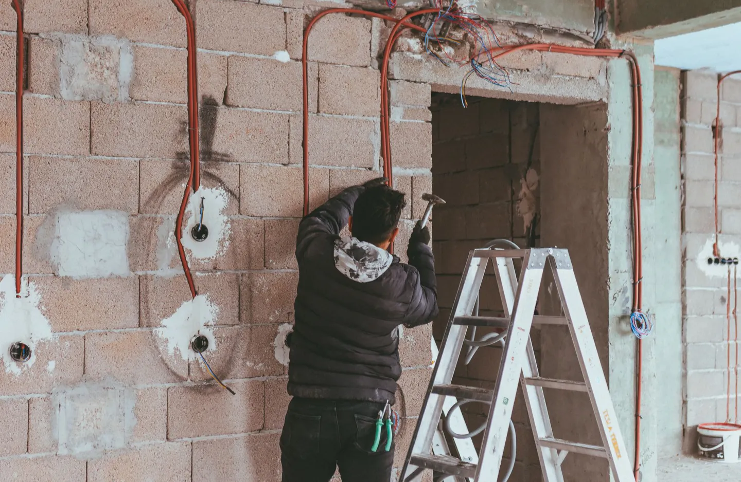 Electrician installing concealed wiring during interior construction